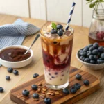 Iced blueberry latte with layers of blueberry syrup, milk, and espresso